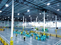the inside of a warehouse with many people standing around